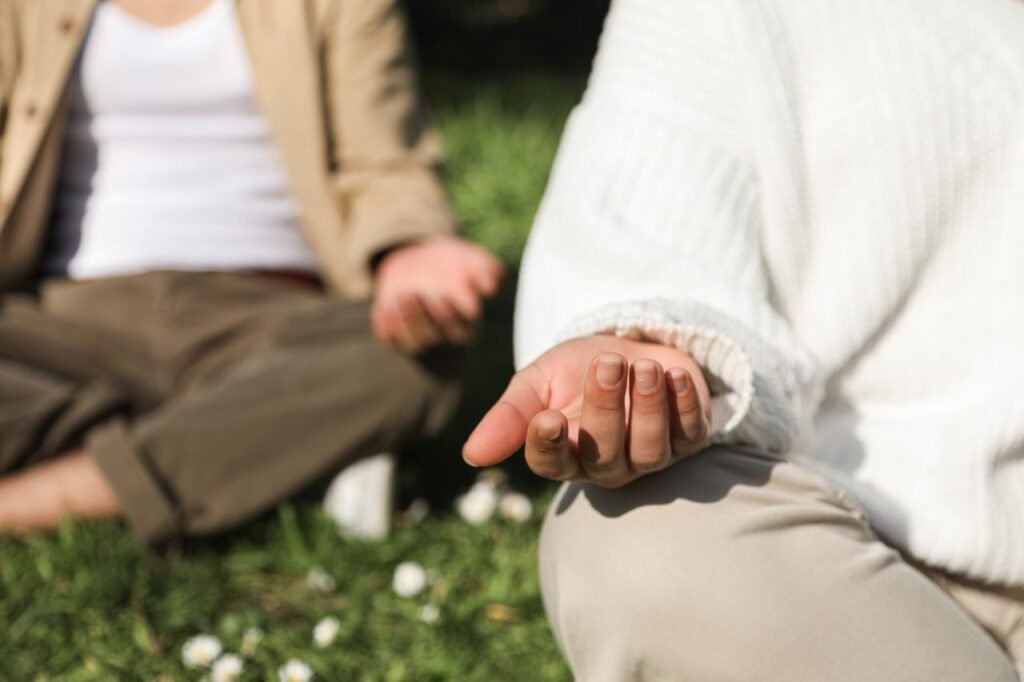 Crafting Captivating Headlines: Your awesome post title goes here Two people meditating outdoors, focusing on hands in a peaceful setting.